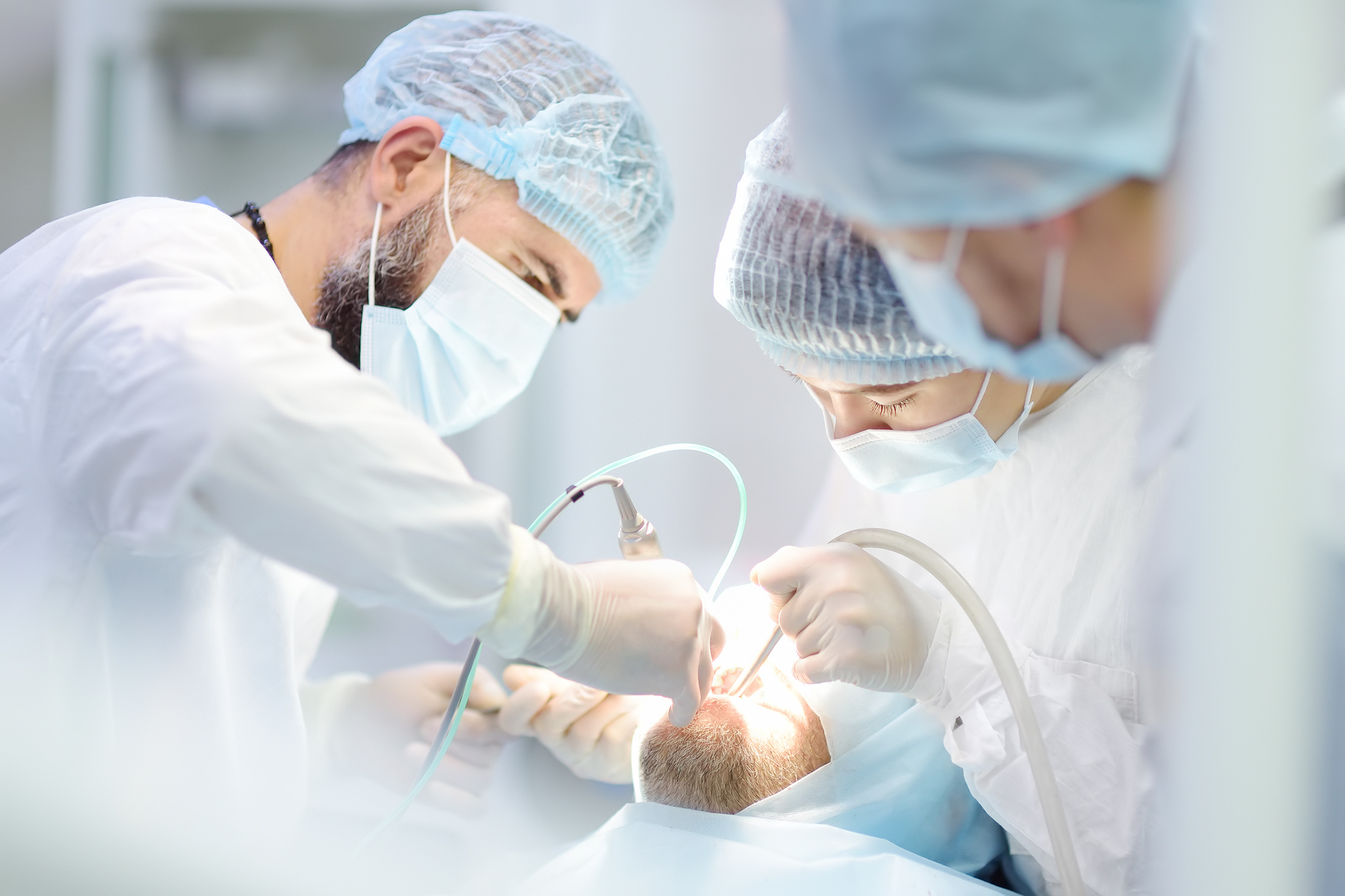 Surgeons and nurse during a dental operation. Anesthetized p